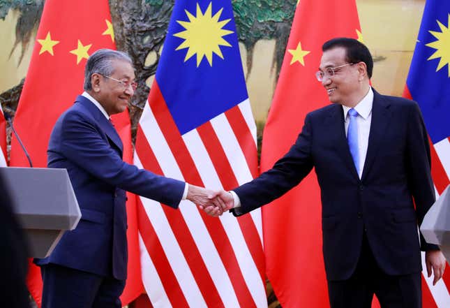 Malaysia's Prime Minister Mahathir Mohamad (L) shakes hands with China's Premier Li Keqiang at the end of a news conference at the Great Hall of the People in Beijing, China, August, 20, 2018.
