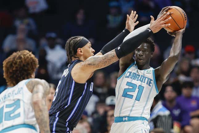 Mar 3, 2023; Charlotte, North Carolina, USA; Charlotte Hornets forward JT Thor (21) tries to pass against Orlando Magic forward Paolo Banchero (5) during the first half at Spectrum Center.