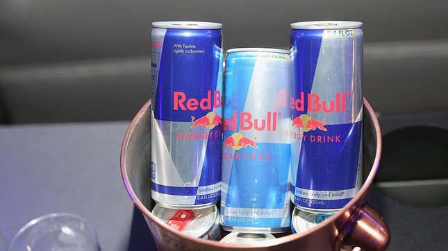 Three cans of Red Bull energy drink chilling in a copper ice bucket