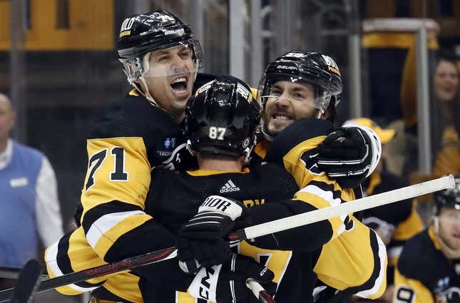 Mar 12, 2023; Pittsburgh, Pennsylvania, USA; Pittsburgh Penguins center Sidney Crosby (87) and center Evgeni Malkin (71) and defenseman Kris Letang (right) celebrate a game winning goal in overtime by Letang to defeat the New York Rangers at PPG Paints Arena. The Penguins won 3-2 in overtime.