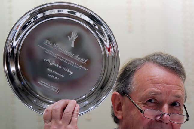 David Alton holds Joshua Wong's Westminster Award