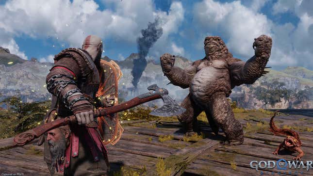 Kratos stands in front of a big monster with his large axe.
