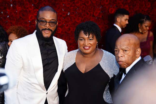 Tyler Perry, Stacey Abrams, and U.S. Rep. John Lewis, D-Ga., pose for a photo on the red carpet at the grand opening of Tyler Perry Studios.