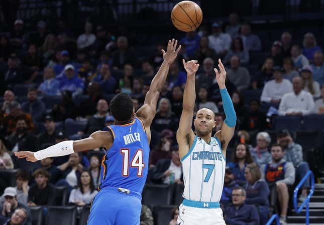 Mar 28, 2023; Oklahoma City, Oklahoma, USA; Charlotte Hornets guard Bryce McGowens (7) shoots a three point basket against Oklahoma City Thunder guard Jared Butler (14) during the second quarter at Paycom Center.