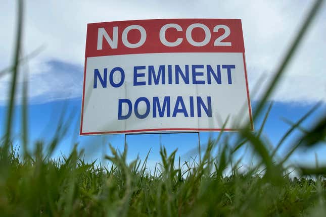 A sign reading "No CO2, no eminent domain" stands along a rural road east of Bismarck, N.D., on Tuesday, Aug. 15, 2023. The sign is in opposition to Summit Carbon Solutions' proposed $5.5 billion, 2,000-mile pipeline network to carry carbon dioxide emissions from dozens of ethanol plants in five states to central North Dakota for permanent storage deep underground. (AP Photo/Jack Dura)
