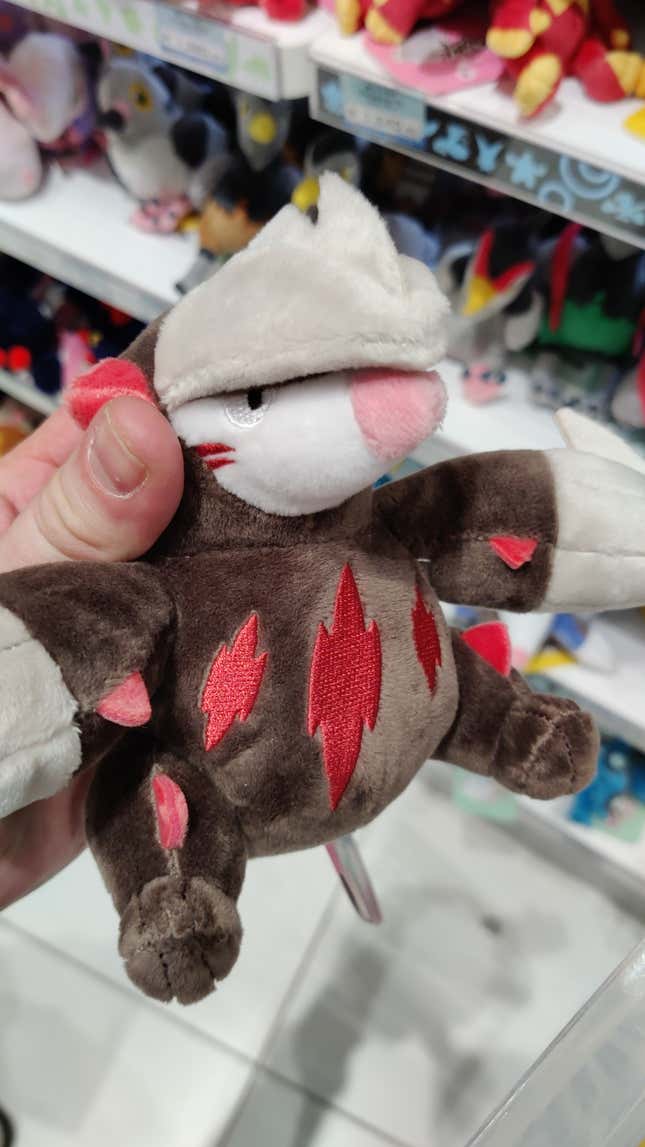 A hand is seen holding an Excadrill plush.