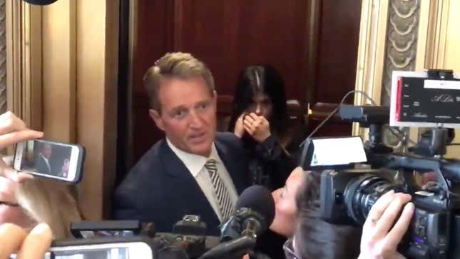 Senator Jeff Flake reacts as protesters approach him in a Capitol elevator.