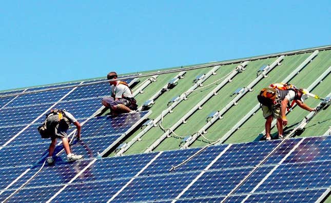 Workers install solar panels on a veterinary hospital in Littlestown, PA, 2010.