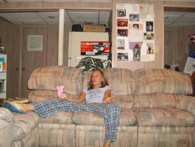 A 17-year-old Alyssa Mercante sitting on a couch wearing an Xbox headset and using a pink controller.