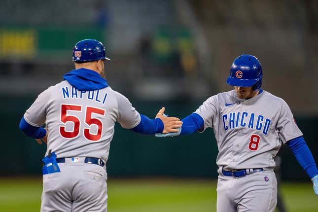 Apr 17, 2023; Oakland, California, USA;  Chicago Cubs left fielder Ian Happ (8) and Chicago Cubs first base coach Mike Napoli (55) celebrate at first base against the Oakland Athletics during the fourth inning at RingCentral Coliseum.