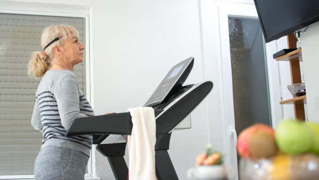 woman in comfortable clothing on treadmill, watching TV