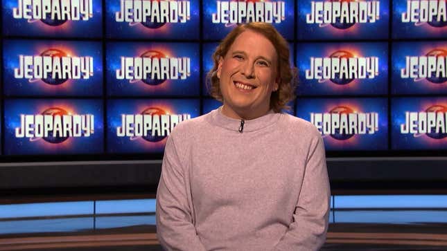 Amy Scnheider smiles while wearing a pink sweater in tribute to her favorite Jeopardy! champion, champion Julia Collins.