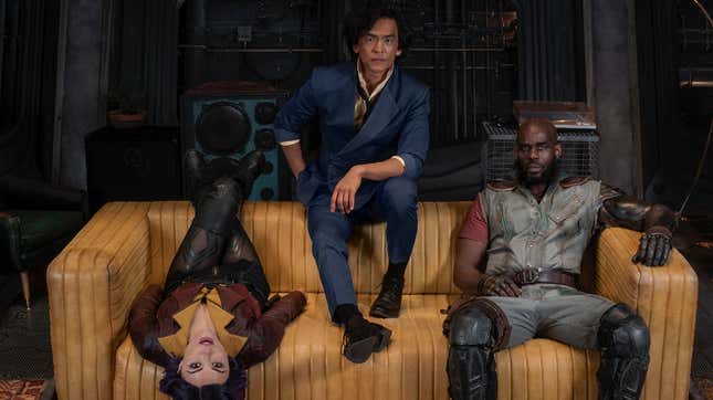 Danielle Pineda's Faye Valentine, John Cho's Spike Spiegel, and Mustafa Shakir's Jet Black lounge on the couch in the Bebop's living room.