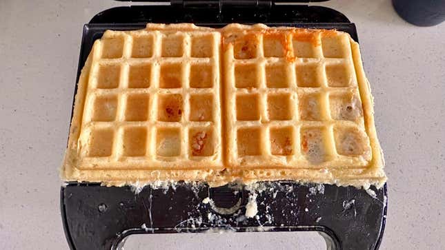 Waffle in a waffle iron with messy edges.