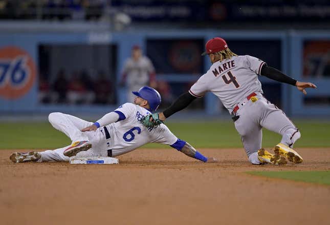 Mar 31, 2023; Los Angeles, California, USA;  Los Angeles Dodgers left fielder David Peralta (6) is tagged out by Arizona Diamondbacks second baseman Ketel Marte (4) on a stolen base attempt in the second inning at Dodger Stadium.
