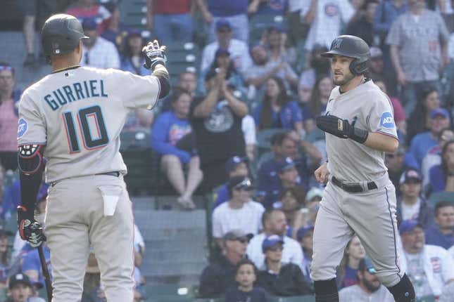 May 7, 2023; Chicago, Illinois, USA; Miami Marlins pinch-runner Garrett Hampson (1) scores on a balk and is greeted by first baseman Yuli Gurriel (10) against the Chicago Cubs during the fourteenth inning at Wrigley Field.