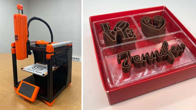 The Cocoa Press 3D chocolate printer sitting on a desk and a box of 3D-printed chocolate words and shapes.