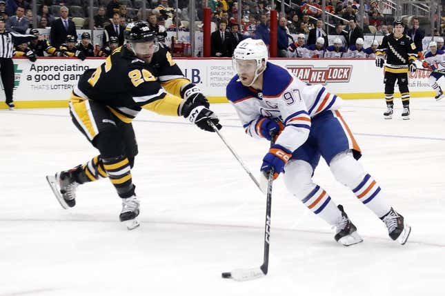 Feb 23, 2023; Pittsburgh, Pennsylvania, USA; Edmonton Oilers center Connor McDavid (97) skates with the puck around Pittsburgh Penguins defenseman Jeff Petry (26) during the third period at PPG Paints Arena. Edmonton won 7-2.