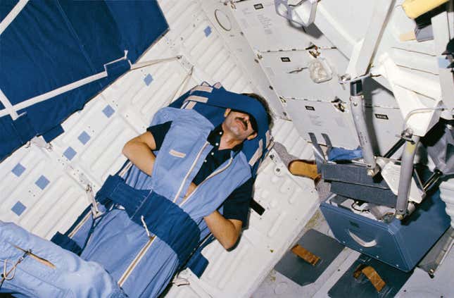 Astronaut Guy Gardner catches some shut-eye onboard the Space Shuttle. 