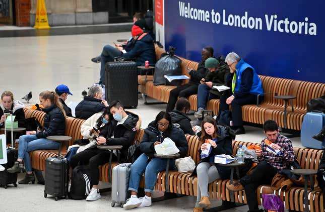 Travelers wear protective face masks as they wait on the concourse at London Victoria train station in central London on March 3, 2020.