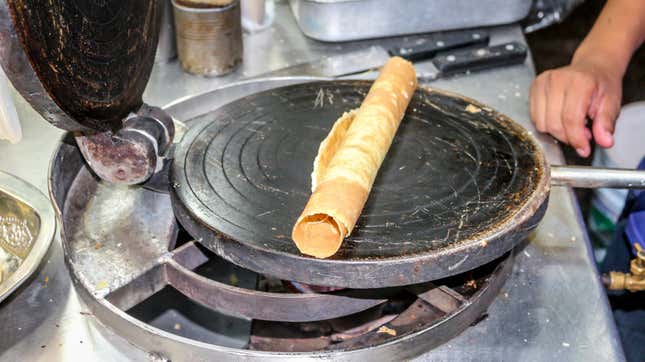 Marquesita rolled up and sitting on waffle iron