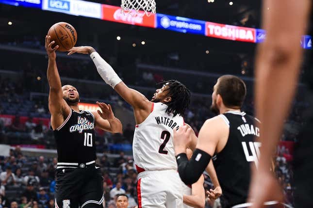 Apr 8, 2023; Los Angeles, California, USA; LA Clippers guard Eric Gordon (10) grabs a rebound against Portland Trail Blazers forward Trendon Watford (2) during the first quarter at Crypto.com Arena.