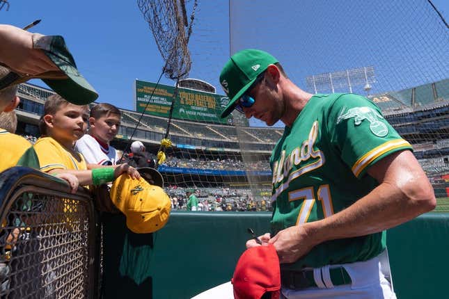 Apr 30, 2023; Oakland, California, USA;  Oakland Athletics bullpen coach Mike McCarthy (71) signs autographs for fans before the start of the first inning against the Cincinnati Reds at RingCentral Coliseum.