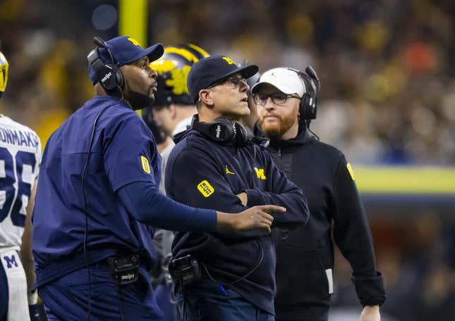Dec 4, 2021; Indianapolis, IN, USA; Michigan Wolverines offensive line coach Sherrone Moore (left), head coach Jim Harbaugh (center) and special teams coordinator Jay Harbaugh against the Iowa Hawkeyes in the Big Ten Conference championship game at Lucas Oil Stadium.