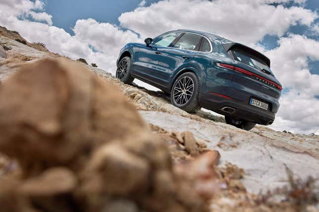 Una foto mal compuesta de un Porsche Cayenne 2024 azul, vista trasera de tres cuartos.