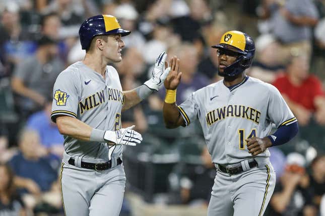 Aug 12, 2023; Chicago, Illinois, USA; Milwaukee Brewers second baseman Andruw Monasterio (14) celebrates with left fielder Mark Canha (21) after they both scored against the Chicago White Sox during the seventh inning at Guaranteed Rate Field.