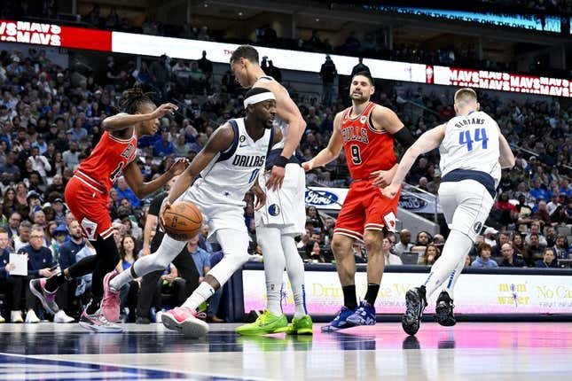 Apr 7, 2023; Dallas, Texas, USA; Dallas Mavericks forward Justin Holiday (0) grabs a rebound against the Chicago Bulls during the first quarter at the American Airlines Center.