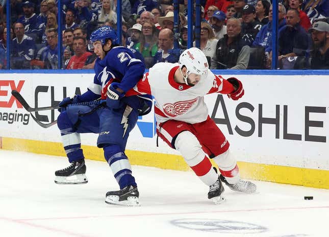 Apr 13, 2023; Tampa, Florida, USA; Tampa Bay Lightning center Brayden Point (21) and Detroit Red Wings defenseman Jake Walman (96) play for the puck during the first period at Amalie Arena.