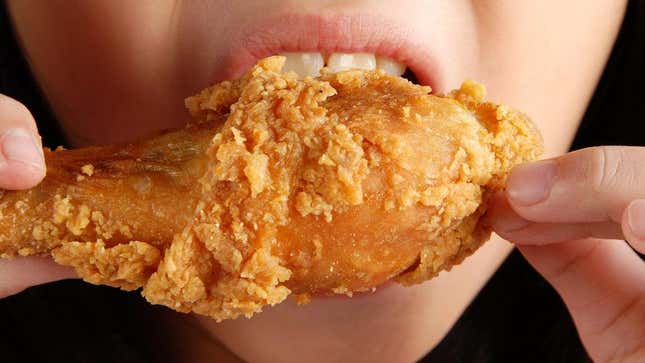 Up-close shot of mouth eating fried chicken