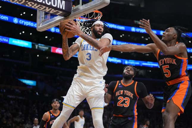 Mar 12, 2023; Los Angeles, California, USA; Los Angeles Lakers forward Anthony Davis (3) rebounds the ball against New York Knicks center Mitchell Robinson (23) and guard Immanuel Quickley (5) in the second half at Crypto.com Arena.
