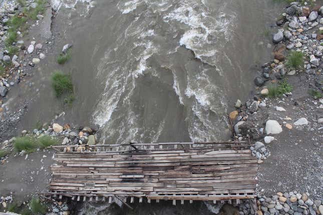 Makeshift wooden plank bridges for motorbikes to cross parts of the braided Dipu Nallah river in the dry season.