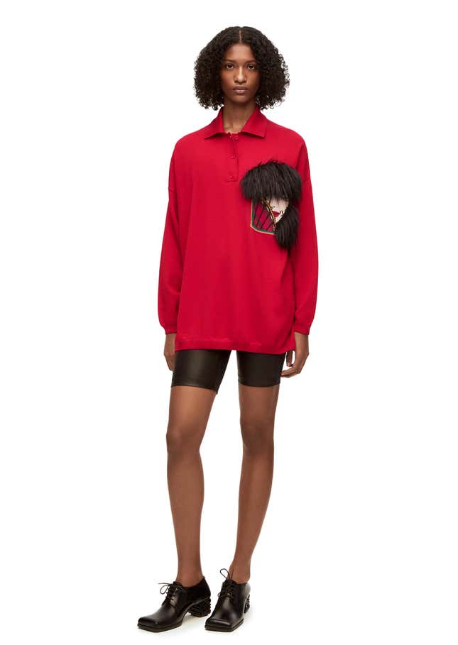 A screenshot of a red polo sweater with the Witch of the Waste embroidered on the breast pocket.