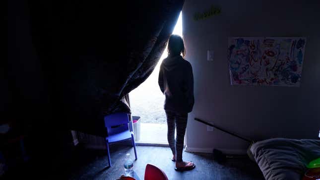 In this Feb. 23, 2021, file photo, Ricki Mills looks out from her home as she waits for a fire hydrant to be turned to get water, in Dallas.