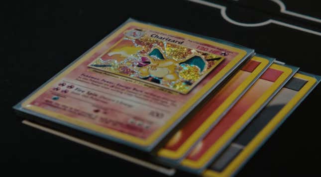 A foil Charizard card sits on a black table. 