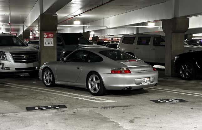 A silver 2003 Porsche 911 Carrera is parked at the terminal of LAX.