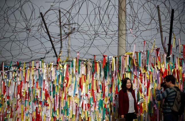 A barbed wire fence decorated with South Korean national flags is pictured near the demilitarized zone which separates North and South Korea in Paju October 31, 2014. On the 25th anniversary of the fall of the Berlin Wall, there are still barriers separating communities around the world, from the barbed wire fence dividing the two Koreas, the fence around the Spanish enclave of Melilla, to the sectarian Peace Wall in Belfast, the Israel-Gaza barrier and the border separating Mexico from the United States. Picture taken October 31, 2014. REUTERS/Kim Hong-Ji (SOUTH KOREA - Tags: ANNIVERSARY CIVIL UNREST POLITICS SOCIETY) ATTENTION EDITORS: PICTURE 19 OF 28 FOR WIDER IMAGE PACKAGE 'THE WALLS THAT DIVIDE' TO FIND ALL IMAGES SEARCH 'WALLS DIVIDE' - RTR4D2WC