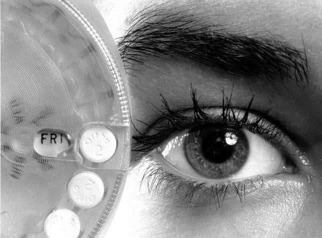 A woman holds a birth control pill dispenser indicating the day of the week in New York in August 1974.
