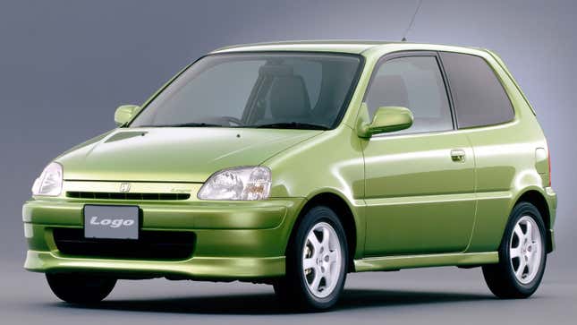 A photo of a green Honda city car parked in a studio. 