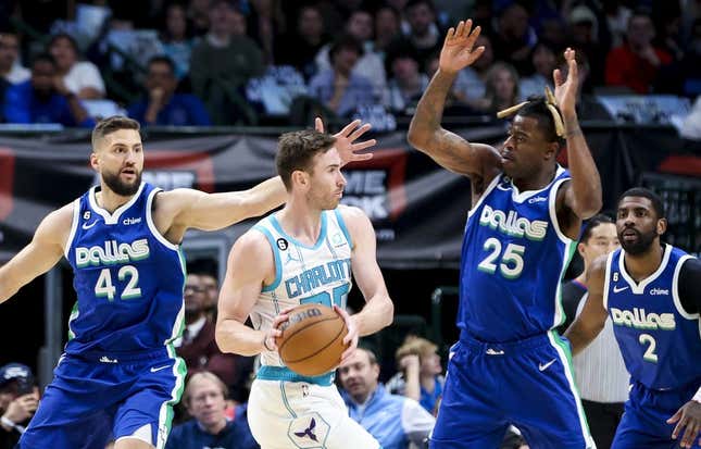 Mar 24, 2023; Dallas, Texas, USA;  Charlotte Hornets forward Gordon Hayward (20) looks to pass as Dallas Mavericks forward Reggie Bullock (25) and Dallas Mavericks forward Maxi Kleber (42) defend during the first quarter at American Airlines Center.