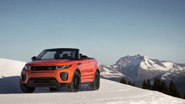 A photo of an orange Range Rover Evoque convertible SUV on a snowy mountain. 