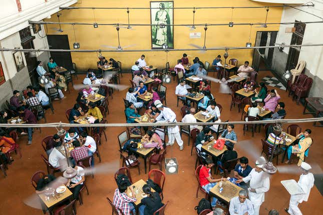 Customers sit beneath a portrait of Rabindranath Tagore in the Indian Coffee House, Kolkata, India.