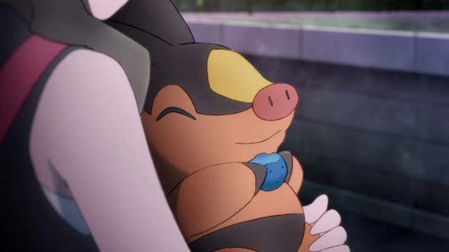 Tepig is seen in the arms of a trainer while eating a blue berry.
