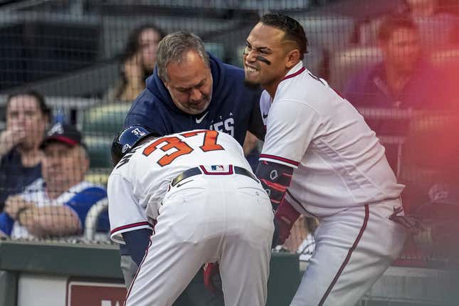 Apr 12, 2023; Cumberland, Georgia, USA; Atlanta Braves shortstop Orlando Arcia (11) is checked after being hit by a pitch against the Cincinnati Reds during the second inning at Truist Park.