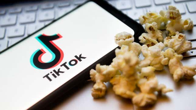 Phone with TikTok pulled up next to pile of popcorn