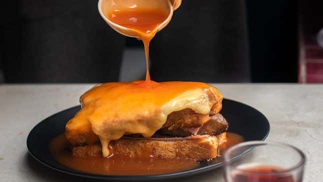 Francesinha sandwich with sauce poured over it