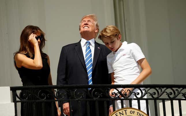 Without his protective glasses on, Trump looks up toward the solar eclipse.